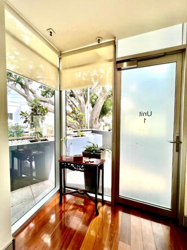 an empty room with a table in front of a glass door at Modern Beachside Suite-Just Steps from Bondi Beach in Sydney