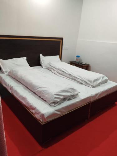 a bed with white sheets and pillows on it at Hotel Snow View in Gupta Kāshi