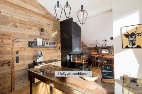 Una cocina con paredes de madera y un mostrador con una mesa. en Haus Sonnblick Penthouse, en Reith im Alpbachtal