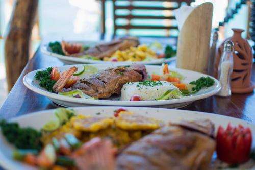 a table with three plates of food on it at Mansion Colonial Boutique Hotel Pool Jacuzzi Bar Restaurant by BTC Group Crypto in Santo Domingo