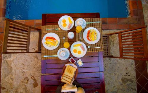 an overhead view of a table with plates of food at Mansion Colonial Boutique Hotel Pool Jacuzzi Bar Restaurant by BTC Group Crypto in Santo Domingo
