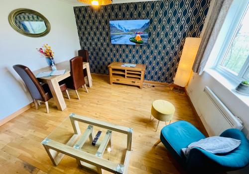 a living room with a blue couch and a table at Brookview 2BR Flat Oxford City Centre Free Parking in Oxford