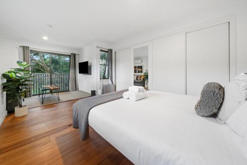 1 dormitorio blanco con 1 cama grande y sala de estar en Gorgeous Self Contained Home, en Sídney