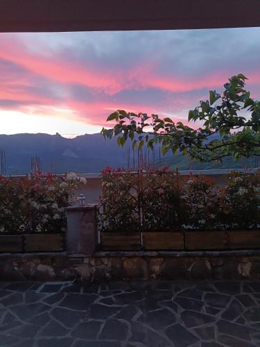 a sunset with a view of the water and trees at orminia house upper level in Monolíthion