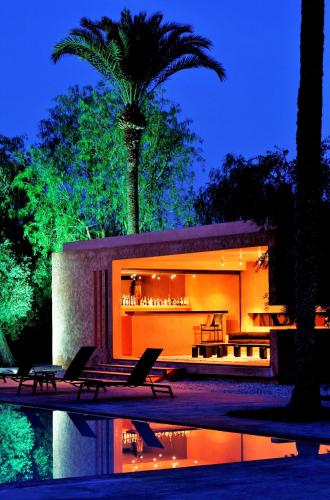 a house with two chairs and a pool at night at Dar Sabra in Marrakech