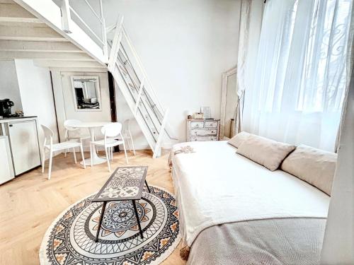 une chambre blanche avec un lit et une table dans l'établissement Mini Duplex 50m du Vieux Port, à Cannes