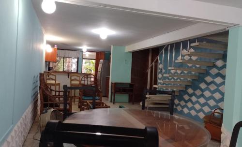 a dining room with a table and a staircase at Acogedora casita en la playa in Boca del Río