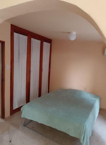 a bedroom with a bed in the corner of a room at Acogedora casita en la playa in Boca del Río