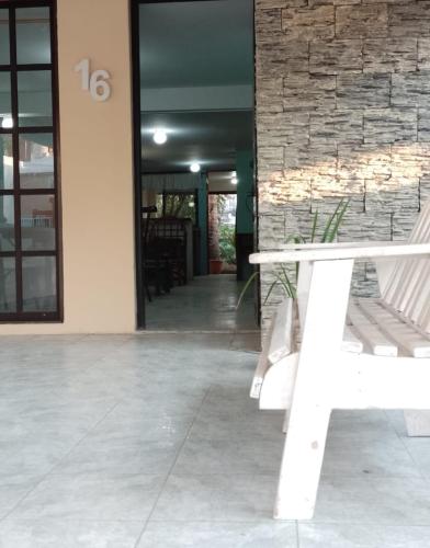 a white bench sitting in front of a building at Acogedora casita en la playa in Boca del Río