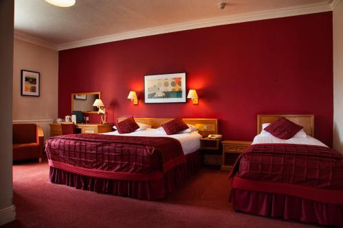 a hotel room with two beds and two lamps at Royal Exeter Hotel in Bournemouth