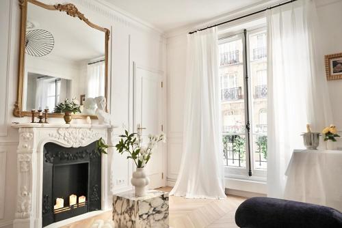 un salon avec une cheminée et un miroir dans l'établissement Splendid Artist Apartment 2P, à Paris