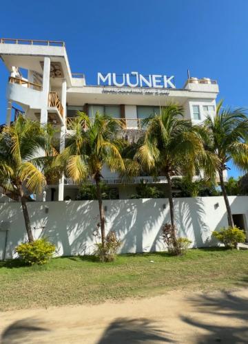 a building with palm trees in front of it at Muúnek Hotel Boutique Art & Spa, adults only in Barra Vieja
