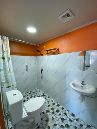 a bathroom with a toilet and a sink at Three Ken Homestay & Cafe in Manado
