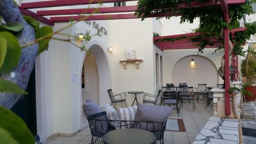 a patio with tables and chairs in a building at Hotel Palatia in Naxos Chora