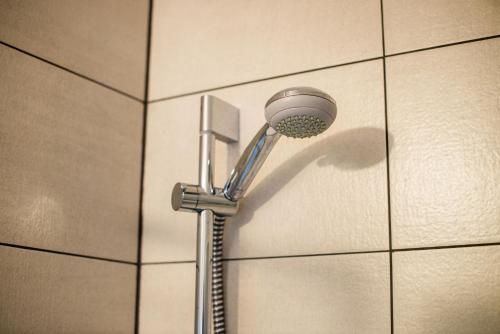 a shower with a shower head on a tiled wall at Turistična kmetija Grabnar in Bled