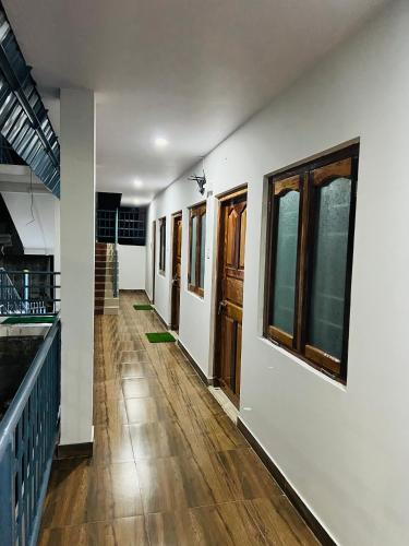 a hallway of a house with wooden floors and windows at Sea Shore Residency in Port Blair