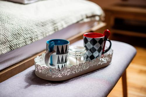 a tray with two mugs on a table next to a bed at Turistična kmetija Grabnar in Bled