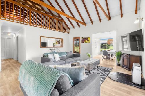 a living room with a couch and a table at Madigan Cottages - Australiana in Lovedale