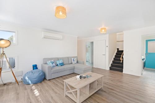 a living room with a couch and a table at Dinga Coastal Hamptons style in Aldinga Beach