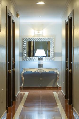 a dressing room with a mirror and a bench at Hotel Doña Luisa in San Luis de Sabinillas