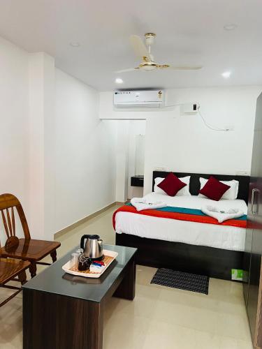 a bedroom with a bed and a table with a tea pot at Sea Shore Residency in Port Blair