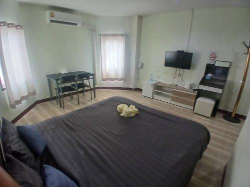 a bedroom with a bed with a stuffed animal on it at Alongkorn hotel by SB in Samut Songkhram