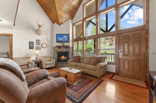 a living room with couches and a fireplace at Lazy JC Lodge lodge in Branson West