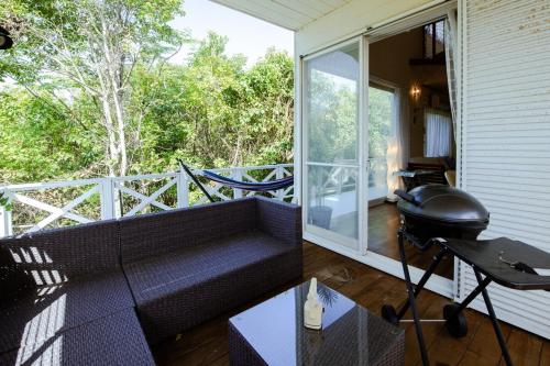 a screened in porch with a couch and a grill at Marine Villa Ilio in Sumoto