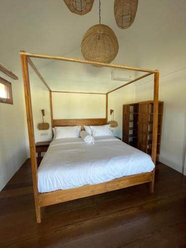 a bedroom with a canopy bed with white sheets at Goofys Hotel - Yoyos Sekongkang Sumbawa in Sekongkang Bawa