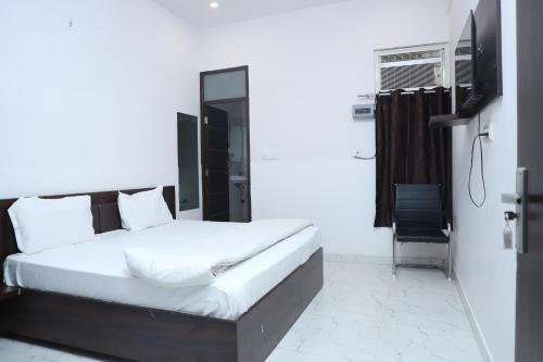 a bedroom with a bed and a flat screen tv at Om pushp residency in Mathura
