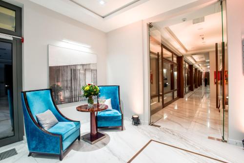 a hallway with two blue chairs and a table at Natura Mazur Resort & Conference in Warchały