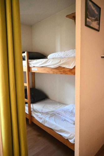 une chambre avec trois lits superposés dans une pièce dans l'établissement Résidence Michailles - En centre station et proche des pistes MAE-1794, à Peisey-Nancroix