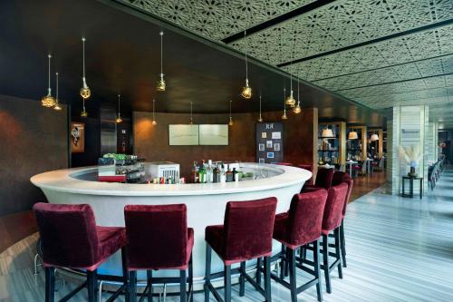 a bar in a restaurant with red chairs at TUI BLUE Maduzi Hotel Bangkok in Bangkok