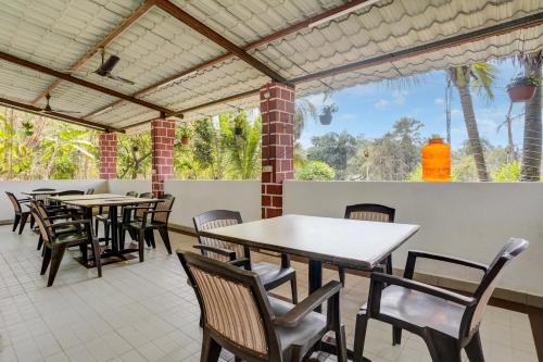 a group of tables and chairs in a patio at Hotel O Shree Prabhat in Mumbai