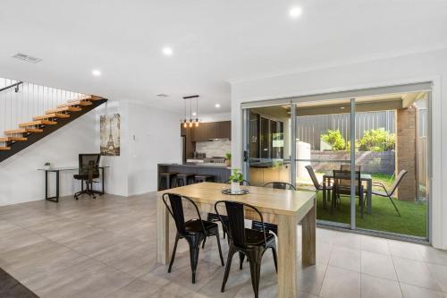 a dining room and kitchen with a table and chairs at Bendigo Signature Accommodation on Honeysuckle in Bendigo