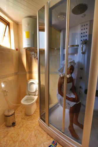 a woman standing in a shower in a bathroom at Bete Daniel Hotel in Bahir Dar