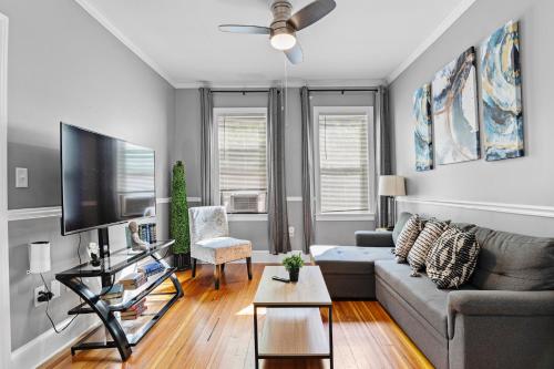a living room with a couch and a flat screen tv at Spacious apartments near Ashmont in Boston