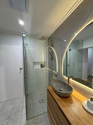a bathroom with a sink and a glass shower at Teringie Retreat with Breathtaking Views in Norton Summit