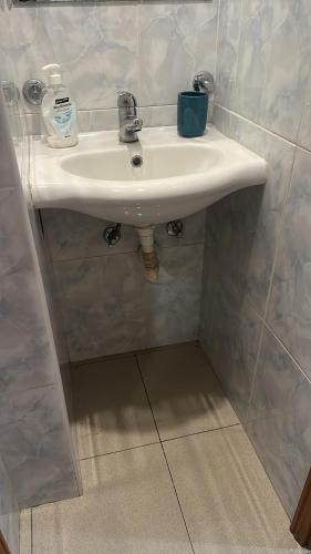 a white sink in a tiled bathroom at Sossego in paradise in Ponta Delgada