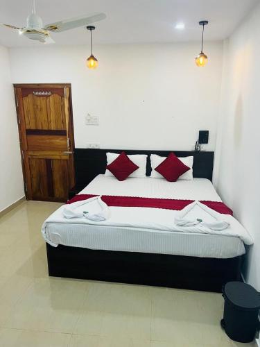 a bedroom with a bed with red and white pillows at Sea Shore Residency in Port Blair