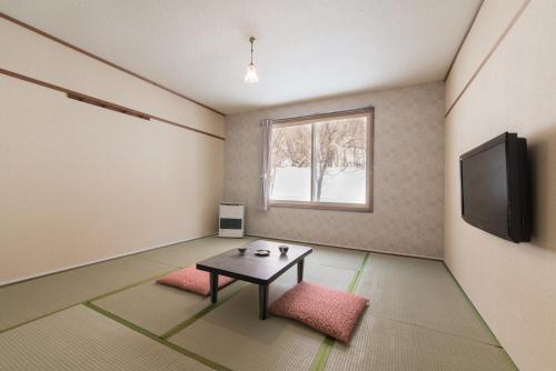 a living room with a table and a tv at SHIRETOKO Kokun Kekun in Shari