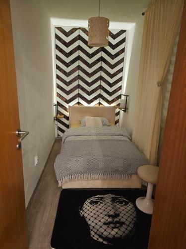 a bedroom with a bed and a striped wall at Batala1-City marina apartment with secured private parking in Dubrovnik