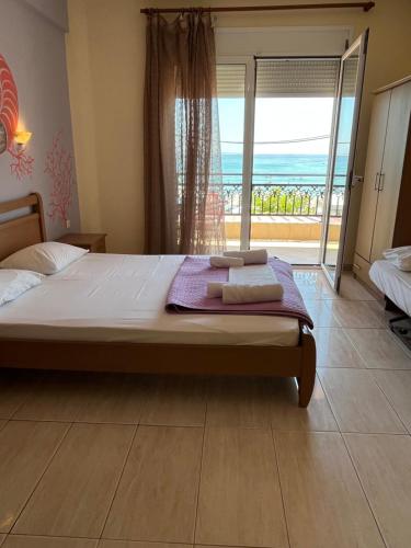 a bedroom with a large bed and a large window at Studios-Heaven in Chrysi Ammoudia