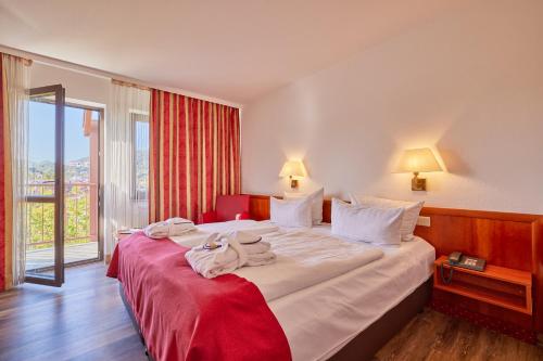 a hotel room with a large bed with towels on it at Mercure Hotel Bad Duerkheim An Den Salinen in Bad Dürkheim