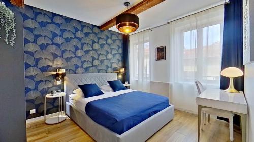 - une chambre bleue avec un lit et un bureau dans l'établissement Appartement Nancy, à La Celle-sous-Gouzon