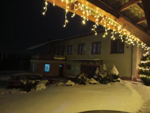 a house with a christmas tree and lights at Apartmán Ústie in Trstená