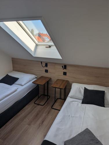 a small room with two beds and a window at Penzion Ema B&B in Prostějov