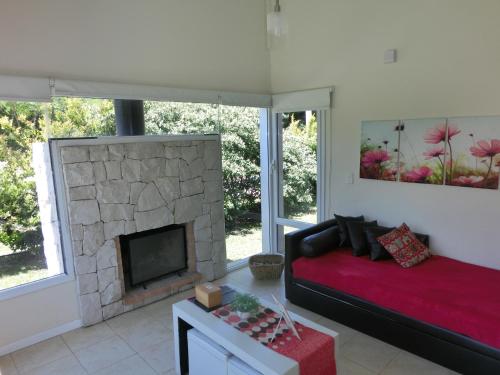 a living room with a couch and a fireplace at Complejo Aires del Bosque in Chascomús