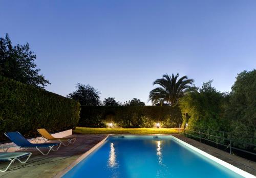 una piscina in un cortile con due sedie e un tavolo di Cuevas del Pino Turismo Rural y Emocional SL a Villarrubia