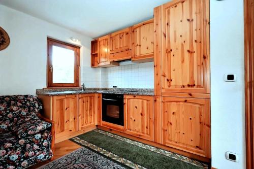 eine Küche mit Holzschränken und einer schwarzen Mikrowelle in der Unterkunft Résidence Beauregard - Beauregard 6 MAE-6421 in Les Houches